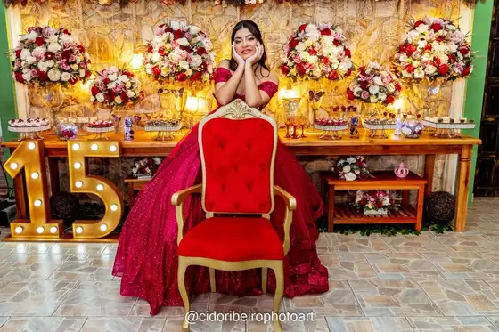 Debutante na poltrona diante da mesa de doces